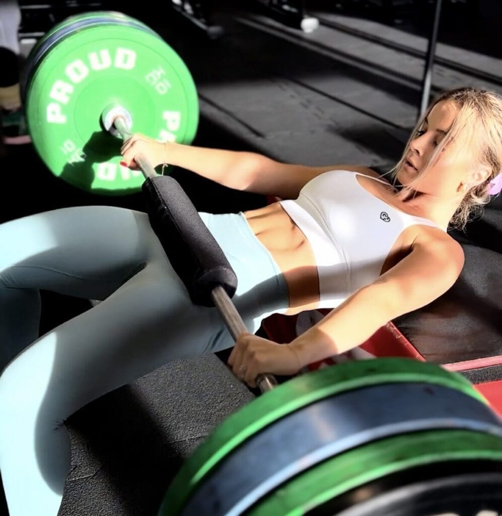 Klientka wykonuje hip thrust z asekuracją trenera personalnego Wrocław