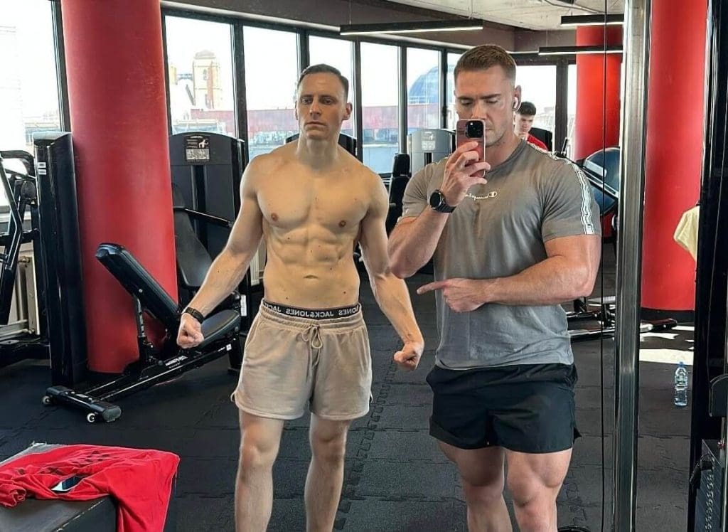 Trener personalny Wrocław podczas analizy sylwetki klienta na siłowni – porównanie efektów treningowych